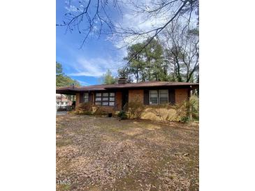 Charming brick home with a covered front porch and mature landscaping, offering a classic appeal at 1115 Park Ave, Henderson, NC 27536