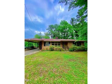 Charming single-story brick home with a carport and well-maintained lawn at 1115 Park Ave, Henderson, NC 27536