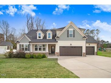 Charming two-story home with well-manicured lawn and a three-car garage at 147 Everwood Dr, Four Oaks, NC 27524