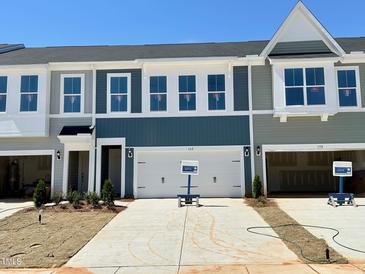 Modern townhomes featuring a two-car garage, concrete driveway and manicured landscaping at 162 Nimble Way # 225, Clayton, NC 27520