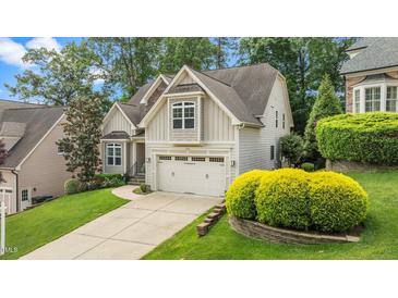 Charming two-story home with an attached garage, manicured lawn, and beautiful landscaping at 1721 Frenchwood Dr, Raleigh, NC 27612