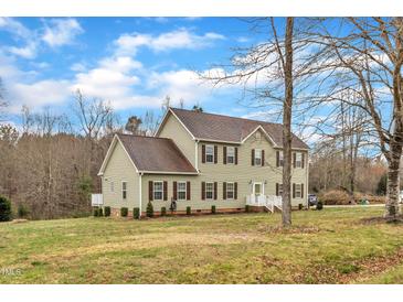 Charming two-story home features a well-manicured lawn and classic architecture under a bright, partly cloudy sky at 250 Spring View Ln, Pittsboro, NC 27312