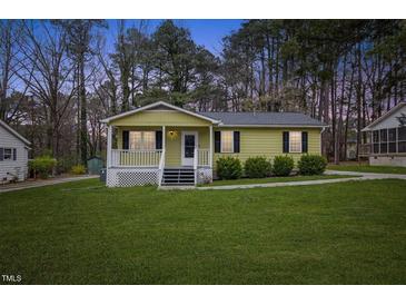 Charming single-story home features a covered porch, well-maintained lawn, and mature trees at 304 22Nd St, Butner, NC 27509