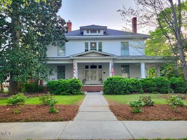 Charming two-story home with well-maintained landscaping and welcoming front porch at 309 College St, Oxford, NC 27565
