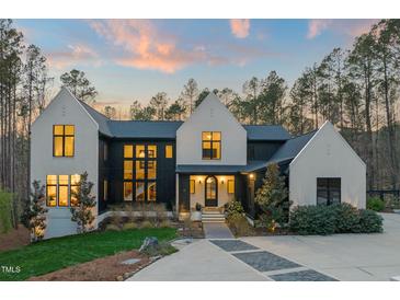Stunning two-story home featuring a modern black and white exterior with a well-manicured lawn and inviting entryway at 336 Timberline Dr, Pittsboro, NC 27312