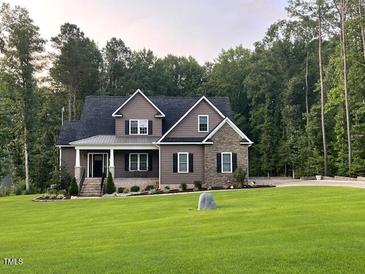 Traditional home featuring a covered front porch and a large grassy yard at 442 Hunters Pointe Rd, Nashville, NC 27856