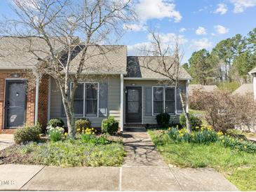 Charming home featuring a well-manicured front yard with lush landscaping and inviting walkway at 60 Justin Ct, Durham, NC 27705