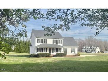 Charming two-story home boasts a welcoming porch and well-manicured lawn surrounded by mature trees at 723 Whitt Town Rd Rd, Roxboro, NC 27574