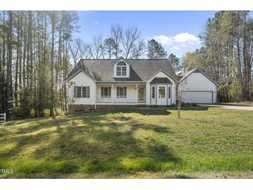 Charming home featuring a classic design, complemented by a well-manicured front lawn and natural surroundings at 1012 Mountain Laurel Dr, Raleigh, NC 27603