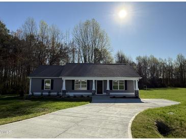 Charming one story home with a long concrete drive and meticulously landscaped front yard at 108 Faucette Dr, Selma, NC 27576