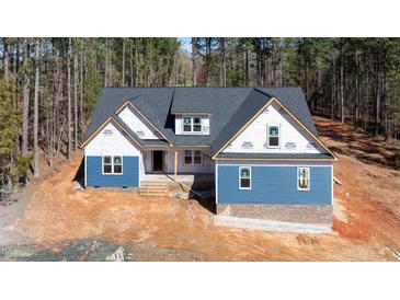 New construction home featuring blue siding, brick accents, and a modern roof design at 110 Purslane Dr, Franklinton, NC 27525