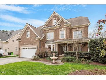 A beautiful two-story brick house featuring a manicured lawn and a lovely water fountain at 113 Kings Castle Dr, Apex, NC 27502
