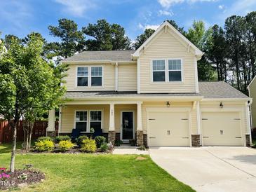 Charming two-story home with a well-manicured lawn and inviting front porch at 303 Fortress Dr, Morrisville, NC 27560
