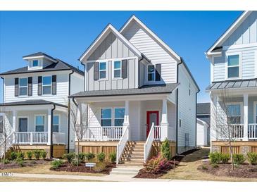 Charming two-story home with a welcoming front porch and well-manicured landscaping at 305 Wash Hollow Dr, Wendell, NC 27591