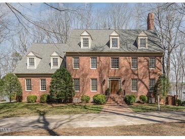Charming brick home featuring dormer windows, manicured landscaping, and a welcoming front entrance at 4808 Clubview Ct, Fuquay Varina, NC 27526