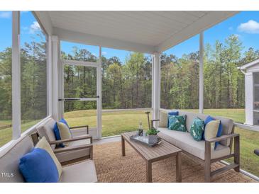Inviting screened porch featuring comfortable seating and scenic views of the backyard landscape at 1131 Pate Farm Ln, Durham, NC 27703