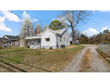Charming home with a front porch, gravel driveway, and a spacious lawn at 1721 Raleigh Rd, Henderson, NC 27536