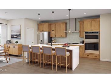 Beautiful kitchen with a large island, stainless steel appliances, wooden cabinets and stylish pendant lights at 2009 Trident Maple Ln, Chapel Hill, NC 27517