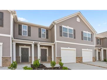 Charming townhome featuring gray siding, white trim, a garage, and a welcoming front porch at 2836 Egert Dr, Haw River, NC 27258