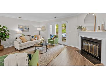 Bright living room boasts hardwood floors, fireplace, and glass patio doors leading to outdoor space at 3111 Coachmans Way, Durham, NC 27705