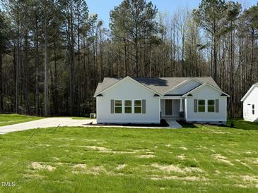 Charming single-story home featuring a well-manicured lawn and a concrete driveway at 325 Magnolia Run Way, Benson, NC 27504