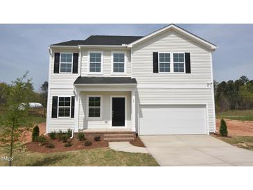 Charming two-story home with black shutters, white siding, a two-car garage, and a well-manicured lawn at 35 Calabria Ct, Franklinton, NC 27525