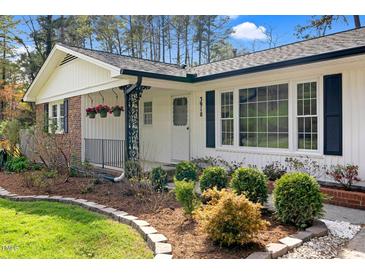 Charming single-story home featuring a brick facade, manicured lawn, and lovely landscaping at 3910 Hillgrand Dr, Durham, NC 27705