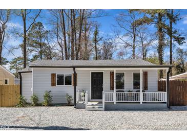 Charming home with white siding, black door, wooden shutters and cozy front porch at 43 Nordan St, Angier, NC 27501