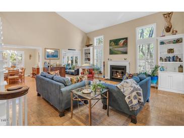 Bright living room features a fireplace, tall ceilings and hardwood floors, creating a cozy atmosphere at 515 Swim & Croquet, Pittsboro, NC 27312