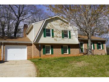 Charming brick home featuring well-manicured lawn and green shutters at 6600 Coach Light Cir, Raleigh, NC 27613
