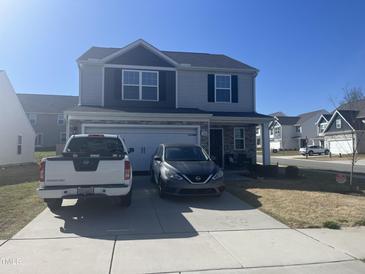 Charming two-story home features a well-maintained lawn, a two-car garage, and a welcoming front porch at 700 Cider Mill Way, Zebulon, NC 27597