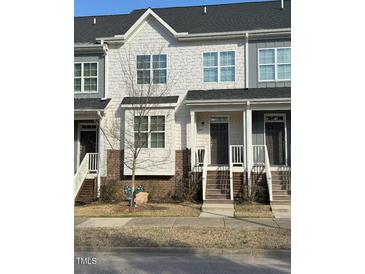 Charming townhome with a stylish exterior, including brick accents, siding and inviting front steps at 829 S Franklin St, Wake Forest, NC 27587