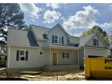 Charming gray home boasts a covered front porch and stylish black shutters at 902 Norwood Ln, Apex, NC 27502