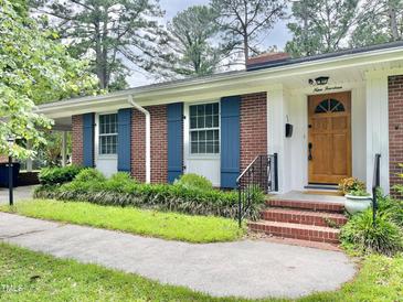 Charming brick home featuring blue shutters, complemented by lush landscaping and a welcoming front porch at 914 S Crescent Dr, Smithfield, NC 27577