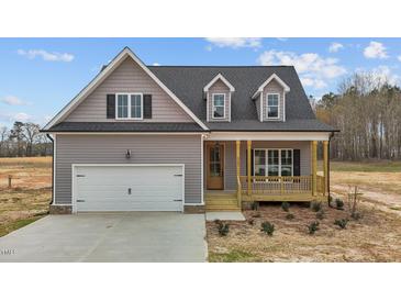 Charming home with gray siding, covered porch, dormers and a white garage door enhancing its curb appeal at 9353 Turkey Way, Middlesex, NC 27557