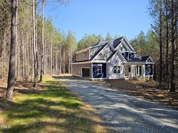 Under-construction, two-story home with shingled accent and ample natural light, nestled in a serene wooded area at 98 Fox Oak Trl, Pittsboro, NC 27312