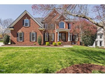 Stately brick home with lush lawn, mature trees, and covered entrance offers timeless elegance at 101 Listokin Ct, Cary, NC 27519