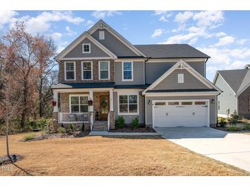 Charming two-story home with stone accents, covered porch, two-car garage, and well-manicured lawn at 197 S Clearbook Ct, Angier, NC 27501