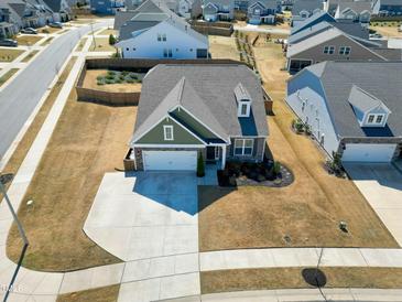 Charming single-story home with a well-manicured lawn and a long driveway in a Gathering-friendly neighborhood at 201 Lingonberry Dr, Holly Springs, NC 27540