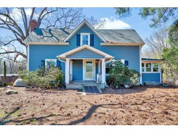 Charming two-story blue home featuring a covered front porch and a well-maintained yard at 290 Collie Rd, Castalia, NC 27816