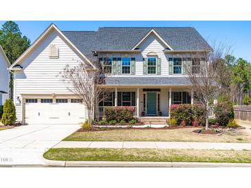 Beautiful two-story home with a well-manicured lawn, inviting front porch, and a two-car attached garage at 3574 Johnson Grant Dr, New Hill, NC 27562