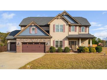 Charming two-story home featuring a combination of stone and siding accents, complemented by a well-manicured lawn at 52 Reserve Dr, Fuquay Varina, NC 27526
