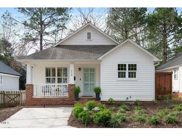 Charming home featuring a covered front porch, brick accents, and a well-manicured lawn at 528 Moseley Ln, Raleigh, NC 27601
