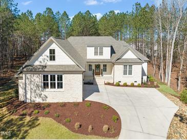 A beautiful shot of the home's exterior elevation, with landscaping and a circular driveway at 56 Mist Wood Ct, Pittsboro, NC 27312
