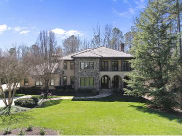 Stunning two-story home features a tile roof and stone accents, nestled on a sprawling green lawn at 7504 Everton Way, Wake Forest, NC 27587