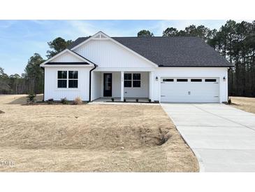 Charming white home with a two-car garage and a well-manicured lawn at 136 Tee Time Ter, Benson, NC 27504