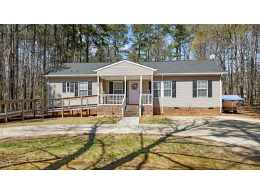 Charming single-story home features a ramp entrance, covered porch, and a well-maintained front yard at 170 Buckaroo Dr, Louisburg, NC 27549