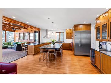 Open kitchen featuring a large island, stainless steel appliances, and hardwood floors at 1714 Park Dr, Raleigh, NC 27605