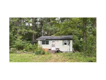 Cozy cottage-style home featuring a quaint front entrance and surrounded by mature trees at 3541 Holden Acres Dr, Wendell, NC 27591