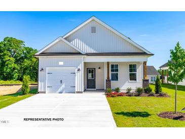 Charming single-Gathering home with attached garage, beautiful landscaping, and inviting front porch at 378 Bluejay St, Clayton, NC 27520